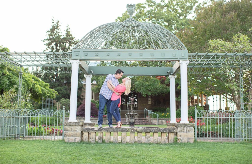 Guy dipping girl under pergola at Gilcrease Museum engagement Tulsa OK 